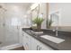 Modern bathroom with double vanity, sleek fixtures, and a glass-enclosed shower, offering a luxurious and functional space at 4015 Elk Creek Ln, Raleigh, NC 27612