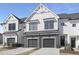 Charming townhome showcases modern architecture with a gray brick facade and attached garages at 4015 Elk Creek Ln, Raleigh, NC 27612