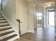 Bright entryway with hardwood floors, a staircase, and natural light streaming through the front door at 592 Barbour Farm Ln, Four Oaks, NC 27524