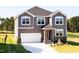 Charming two-story home with gray siding, a white garage door, and a well-manicured front lawn at 592 Barbour Farm Ln, Four Oaks, NC 27524