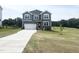 Charming two-story home boasts a modern exterior with gray siding and a well-manicured lawn at 592 Barbour Farm Ln, Four Oaks, NC 27524