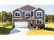 Charming two-story home with gray siding, a white garage door, and a well-manicured front lawn at 592 Barbour Farm Ln, Four Oaks, NC 27524