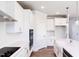 Well-lit kitchen featuring white cabinets, countertops, stainless steel appliances, and wood-look floors at 592 Barbour Farm Ln, Four Oaks, NC 27524