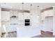 Bright, all-white kitchen featuring a central island, stainless steel appliances, and modern pendant lighting at 592 Barbour Farm Ln, Four Oaks, NC 27524