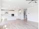 Open concept living room with bright white kitchen, hardwood floors, and plenty of natural light at 592 Barbour Farm Ln, Four Oaks, NC 27524
