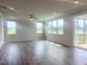 Spacious living room featuring sleek flooring, neutral walls, and abundant natural light from large windows at 592 Barbour Farm Ln, Four Oaks, NC 27524