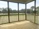 Inviting screened porch with wood flooring and golf course view, perfect for outdoor relaxation at 592 Barbour Farm Ln, Four Oaks, NC 27524