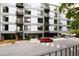 Exterior shot of modern apartment building with balconies, parking lot, and sidewalks at 1300 St Marys St # 208, Raleigh, NC 27605