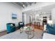 Open living space with kitchen view, featuring cozy teal armchairs and a round glass coffee table at 1300 St Marys St # 208, Raleigh, NC 27605