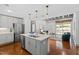 Open-concept living space with a kitchen island, stainless appliances, and view to living room at 1300 St Marys St # 208, Raleigh, NC 27605