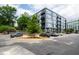 Exterior view of a modern apartment building, showcasing parking lot with reserved parking and sidewalks at 1300 St Marys St # 208, Raleigh, NC 27605