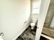 Bright bathroom featuring a window, toilet, sleek black floors, and walk in shower at 122 Southern Estates Dr, Sanford, NC 27330