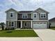 Beautiful two-story home with gray siding, stone accents, and a well-manicured front lawn at 122 Southern Estates Dr, Sanford, NC 27330