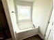 Main bathroom features a soaking tub, tile flooring, and natural light at 122 Southern Estates Dr, Sanford, NC 27330