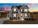 Two-story home with gray siding, landscaped yard, and a three-car garage at 130 Summerlin Dr, Clayton, NC 27527