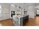 Modern kitchen with white cabinets, gray island, stainless steel appliances, and hardwood floors at 130 Summerlin Dr, Clayton, NC 27527