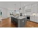 Modern kitchen with white cabinets, gray island, stainless steel appliances, and hardwood floors at 130 Summerlin Dr, Clayton, NC 27527