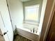 Bright bathroom bathtub with tile flooring and a large window at 316 Bishop Ln, Sanford, NC 27330
