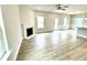 Bright living room featuring a ceiling fan, fireplace, and light wood flooring at 316 Bishop Ln, Sanford, NC 27330