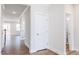 Bright hallway with light hardwood floors, and white doors at 395 Fast Pitch Ln, Four Oaks, NC 27524