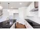 Modern kitchen features granite countertops, stainless steel appliances, and white cabinetry at 395 Fast Pitch Ln, Four Oaks, NC 27524