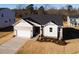 New construction home showcasing a two-car garage and landscaped yard at 411 Fast Pitch Ln, Four Oaks, NC 27524
