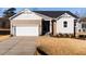 Two-story house with beige siding, white accents, and a two-car garage at 411 Fast Pitch Ln, Four Oaks, NC 27524