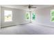 Light-filled bedroom with a ceiling fan and large windows overlooking the outdoor landscape at 427 Fast Pitch Ln, Four Oaks, NC 27524