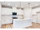 Bright kitchen features white cabinets, an island with a sink, and stainless steel appliances at 427 Fast Pitch Ln, Four Oaks, NC 27524