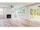 Bright and airy living room with a fireplace, large windows, and access to a screened-in porch at 427 Fast Pitch Ln, Four Oaks, NC 27524