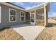 View of a screened back porch with concrete patio, wooden railing, and access door at 52 Gander Dr, Benson, NC 27504