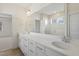 Bathroom featuring a double vanity, quartz countertop, a large mirror, and a tiled shower at 52 Gander Dr, Benson, NC 27504