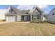 Single Gathering home showcasing stone accents, gray siding, two-car garage, and a well-kept lawn at 52 Gander Dr, Benson, NC 27504