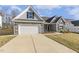 Charming single Gathering home featuring stone accents, gray siding, two-car garage and concrete driveway at 52 Gander Dr, Benson, NC 27504