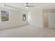 Spacious main bedroom featuring two windows, a ceiling fan, neutral walls, and carpet at 52 Gander Dr, Benson, NC 27504