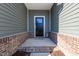 Welcoming entrance to a house with a black door and brick base at 565 Marthas View Way, Wake Forest, NC 27587