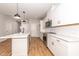 Modern kitchen featuring white cabinetry, stainless steel appliances, and a quartz countertop island with stylish pendant lights at 565 Marthas View Way, Wake Forest, NC 27587