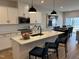 Bright kitchen featuring white cabinets, stainless steel appliances, and a large island with bar seating at 565 Marthas View Way, Wake Forest, NC 27587