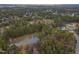 Aerial view of community showing pond, lush trees, and surrounding homes at 2909 Frances Marie Ln, Raleigh, NC 27603