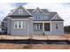 Newly constructed two-story home featuring gray brick, a covered porch, and a dark roof at 2909 Frances Marie Ln, Raleigh, NC 27603