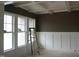 An unfinished living room with paneled walls and large windows providing ample natural light at 2909 Frances Marie Ln, Raleigh, NC 27603