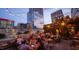 Outdoor seating area with string lights, people at tables and city buildings in the background at 2909 Frances Marie Ln, Raleigh, NC 27603
