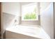Bathroom featuring a new bathtub, tiled walls, and a bright window at 196 Abingdon Farms Dr, Selma, NC 27576