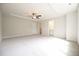 Empty primary bedroom with tray ceiling, large window, and doors leading to closet and bath at 196 Abingdon Farms Dr, Selma, NC 27576