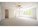 Large primary bedroom featuring tray ceilings, carpet flooring, ceiling fan and natural light at 196 Abingdon Farms Dr, Selma, NC 27576