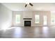 Bright living room featuring a fireplace, wood-look floors and large windows at 196 Abingdon Farms Dr, Selma, NC 27576
