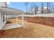 View of a flat backyard with a covered patio and freshly planted landscaping at 232 Berry Mill Ln # 201, Raleigh, NC 27603