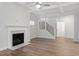 Well-lit living room featuring a fireplace, coffered ceiling and hardwood flooring, next to staircase at 232 Berry Mill Ln # 201, Raleigh, NC 27603