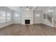 Bright living room with coffered ceiling, fireplace, and hardwood floors, complemented by large windows and staircase at 232 Berry Mill Ln # 201, Raleigh, NC 27603