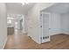 Open living room with hardwood floors, white trim, and a view of the kitchen and dining area at 232 Berry Mill Ln # 201, Raleigh, NC 27603